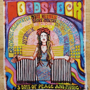 May include: A colorful vintage-style poster for the Woodstock Music and Art Fair. The poster features a woman with long brown hair and a flower crown, standing in front of a rainbow arch with the names of the performers listed in a circle around her. The text at the bottom reads "3 Days of Peace and Music".