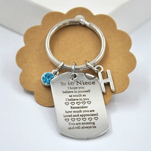 May include: Silver keyring with a blue rhinestone charm and a tag that reads "To My Niece I hope you believe in yourself as much as I believe in you Remember how much you are loved and appreciated You are amazing and will always be" with a letter "H" charm.
