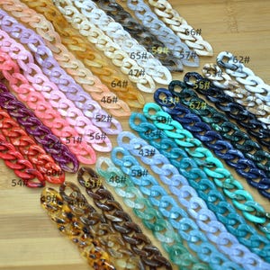 May include: Assortment of colorful plastic chain links in various colors and patterns, including turquoise, blue, purple, pink, red, orange, brown, and white. The chain links are numbered with a black marker.