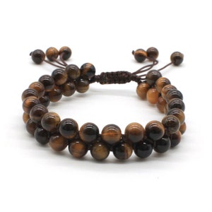 May include: A brown and gold tiger's eye beaded bracelet with a brown cord closure.
