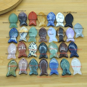 May include: Assortment of 25 gemstone fish pendants in various colors and patterns, including amethyst, yellow jade, red jasper, green aventurine, lapis lazuli, black obsidian, sodalite, white howlite, spectrolite, strawberry crystal, crazy lace agate, tiger eye, opal, green crystal, lepidolite, gold sand, rose quartz, amazonite, dragon blood stone, blue goldstone, clear quartz, rainbow stone, and rose rhodonite.