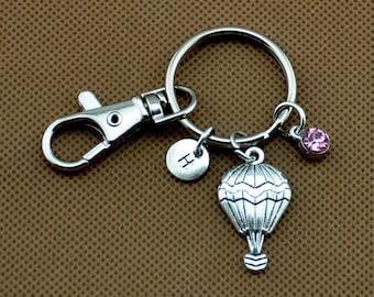 Keychain with the word serene stamped on a washer with hot air balloon charm and green crystal.