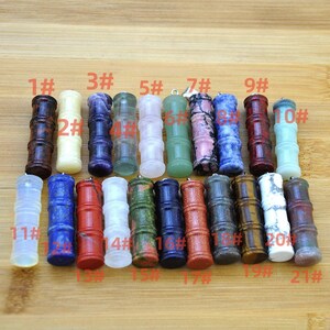 May include: A selection of twenty-one gemstone pendants, each crafted in a bamboo style. The pendants showcase a variety of colours, such as brown, purple, green, pink, blue, red, and white. Each pendant features a silver loop for suspension.