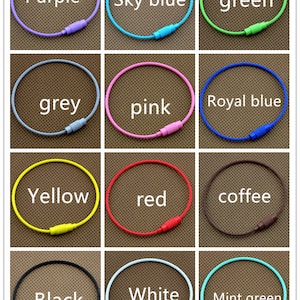 May include: Twelve different colored key rings, each with a metal clasp. The colors are purple, sky blue, green, grey, pink, royal blue, yellow, red, coffee, black, white, and mint green.