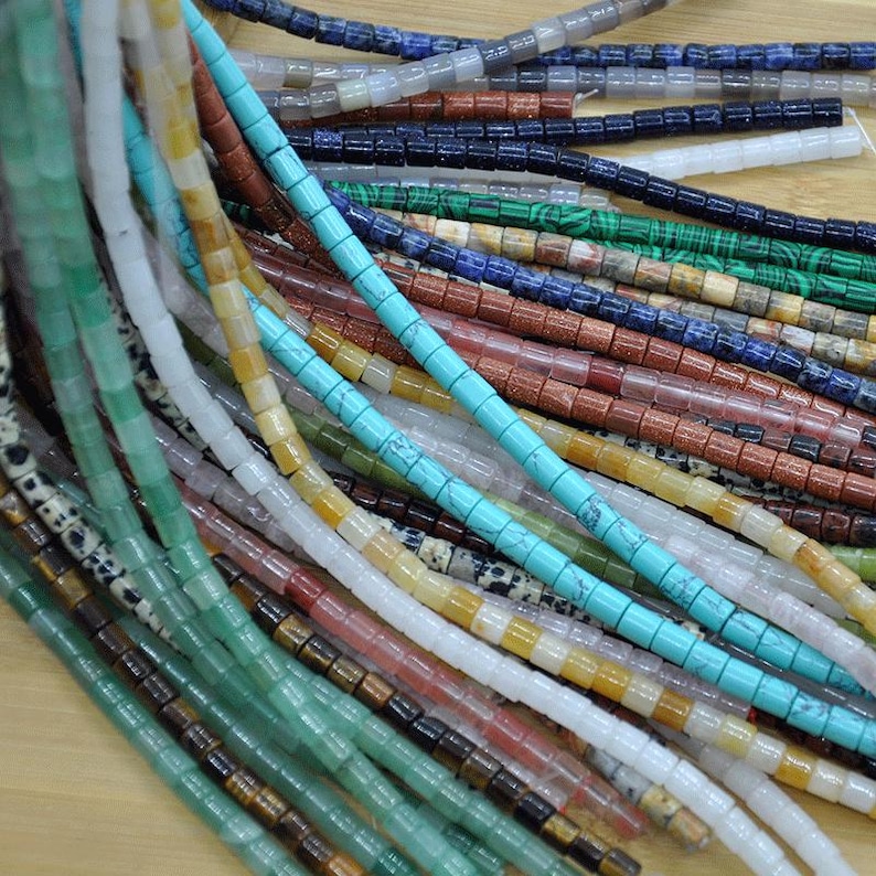 May include: A variety of gemstone beads in different colors and patterns, including turquoise, green, white, brown, and red. The beads are strung on a string and are ready to be used for jewelry making.
