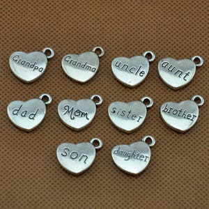 Puede incluir: Doce dijes de plata en forma de coraz&oacute;n con diferentes palabras de miembros de la familia grabadas en ellos. Las palabras son: "Grandpa", "Grandma", "Uncle", "Aunt", "Dad", "Mom", "Sister", "Brother", "Son", "Daughter".