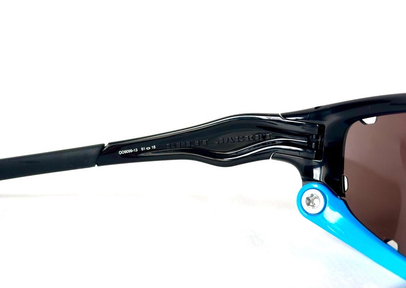 May include: Black Oakley sunglasses with a blue temple arm and the text "RADAR JACKET" on the frame.