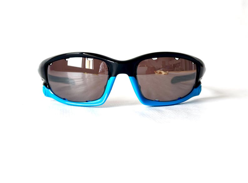 May include: Black and blue wraparound sunglasses with dark lenses.