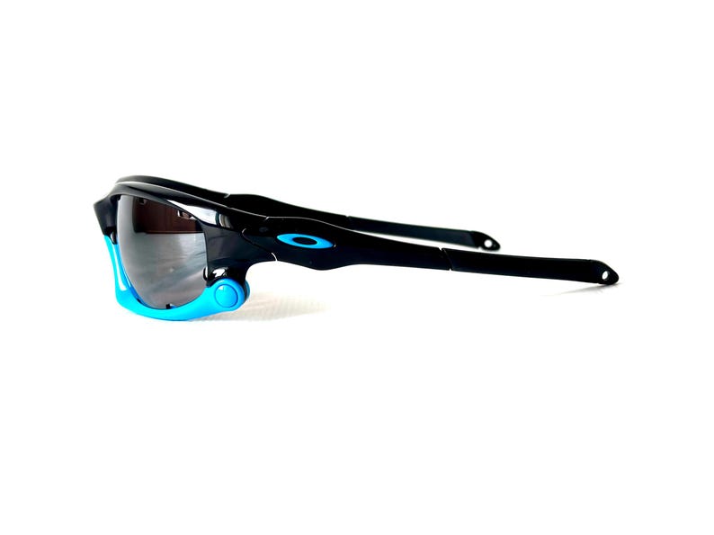 May include: Black sunglasses with blue accents. The sunglasses have a wraparound design and a dark lens.