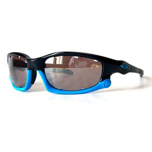 May include: Black and blue sunglasses with a reflective lens. The sunglasses have a sporty design and are made of durable plastic.