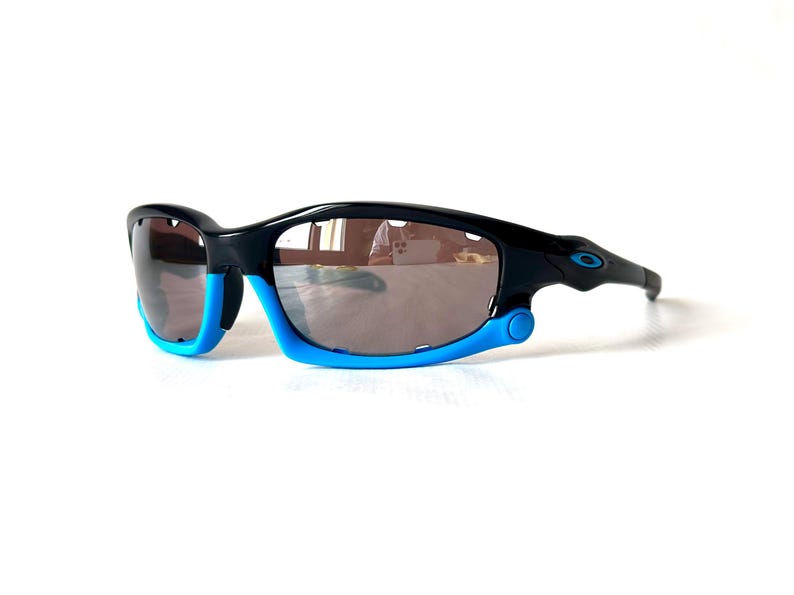 May include: Black and blue sunglasses with a reflective lens. The sunglasses have a sporty design and are made of durable plastic.