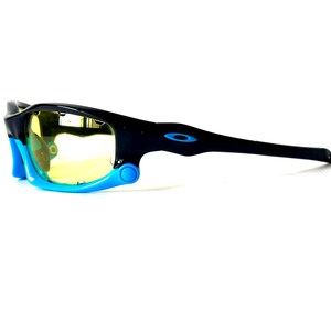 May include: Black and blue sunglasses with yellow lenses. The sunglasses have a sporty design and are made of durable plastic.