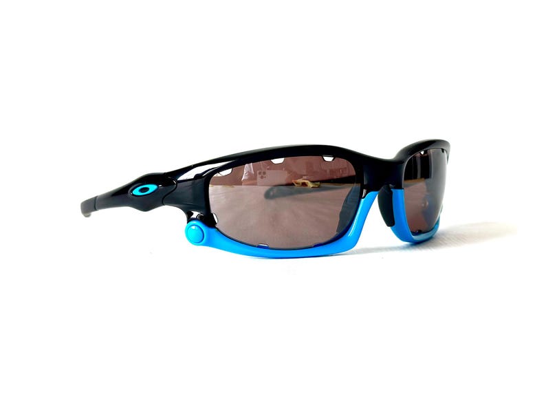 May include: Black and blue sunglasses with a sporty design. The lenses are dark and the frame is made of plastic.