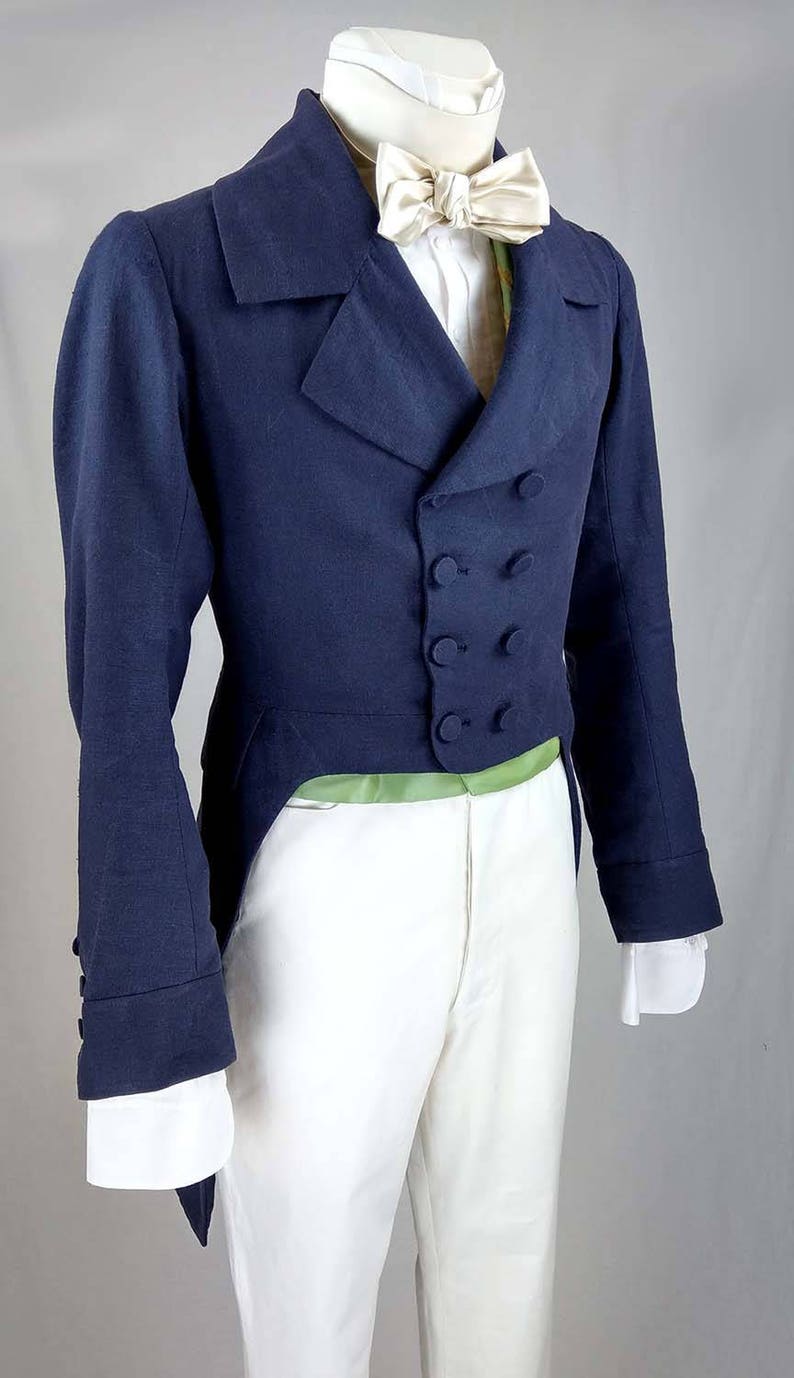 May include: A navy blue tailcoat with a white shirt and a cream-colored bow tie. The tailcoat has a double-breasted closure with four buttons and a long, pointed tail.