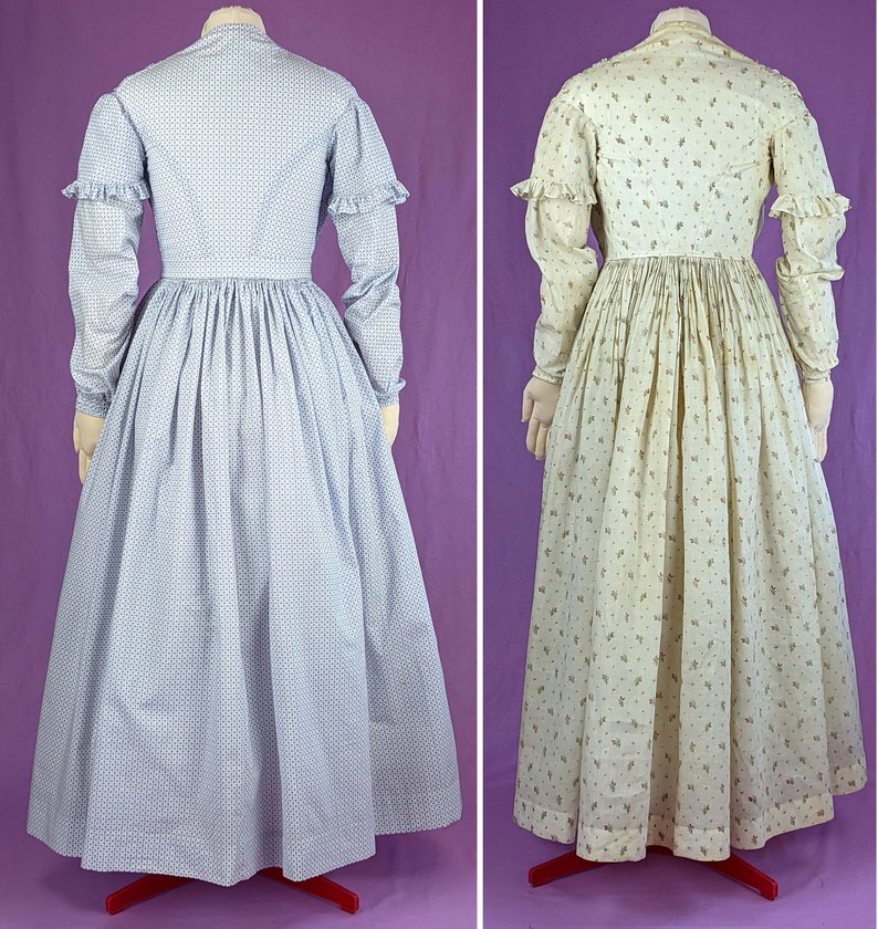 May include: Two vintage dresses, one in a light blue and white pattern and the other in a cream and brown floral pattern. Both dresses have long sleeves and a gathered skirt.