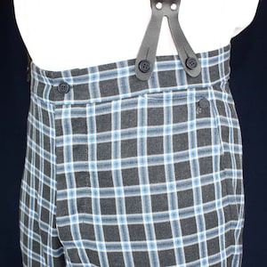 May include: Black and blue plaid pants with a button closure and suspenders. The suspenders are made of black leather and have a button closure.