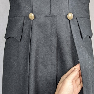 May include: A black tailcoat with two gold buttons on the back. The coat has a single vent in the back.