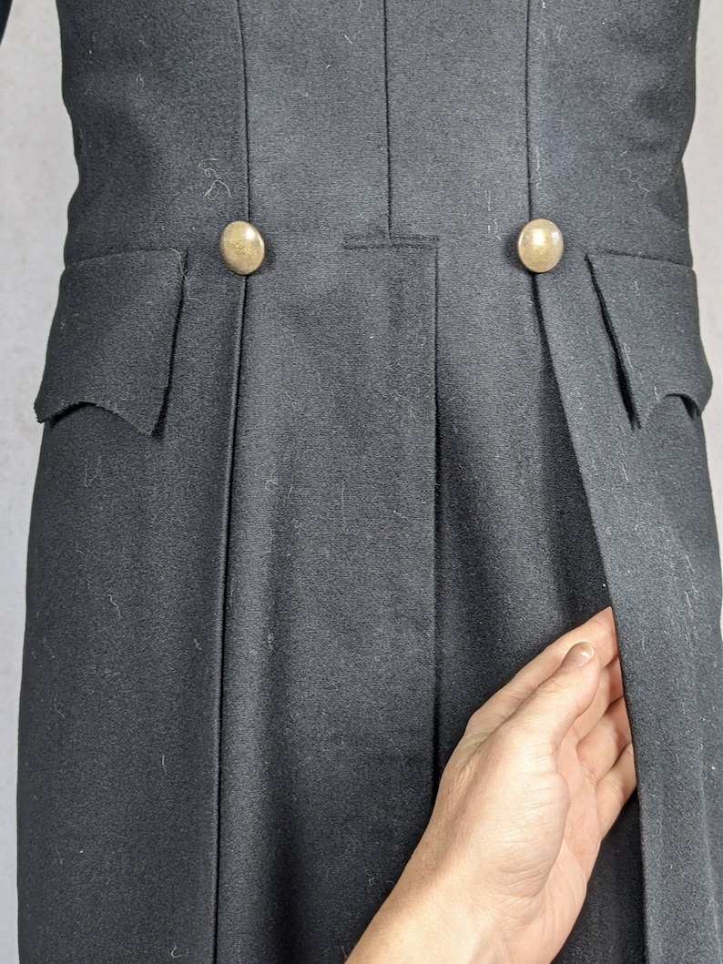 May include: A black tailcoat with two gold buttons on the back. The coat has a single vent in the back.