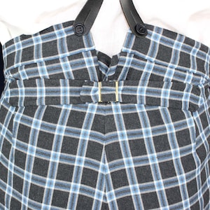 May include: Black and white plaid pants with a blue and white check pattern. The pants have suspenders and a belt.