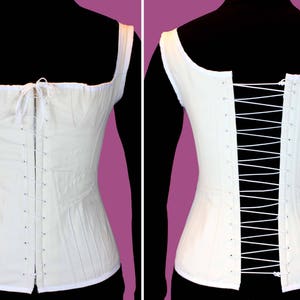 May include: A white cotton corset with a lace-up back and a front closure. The corset is made of a lightweight fabric and has a simple design.