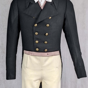 May include: A black tailcoat with gold buttons and a white bow tie. The tailcoat is worn over a white shirt and a pink vest. The person is wearing white pants.