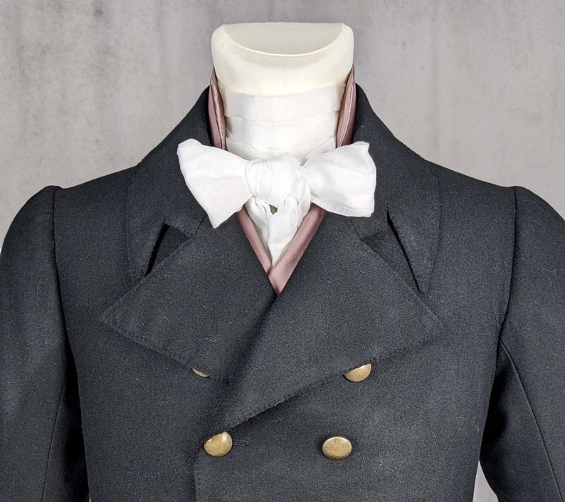 May include: A black double-breasted jacket with gold buttons and a white bow tie with a pink lining.