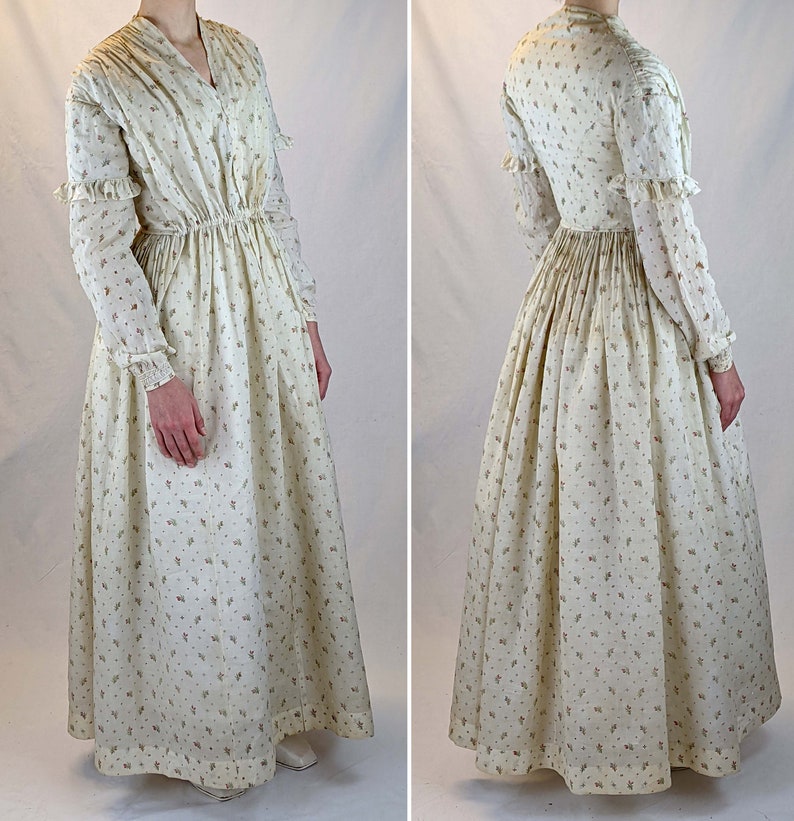 May include: A long-sleeved white dress with a floral print. The dress has a gathered waist and a full skirt.