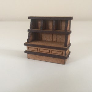 May include: A wooden shelf unit with a brown stain. The shelf has two levels and a small counter with three drawers. The shelf is made of wood and has a rustic look.
