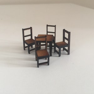 May include: A set of four wooden chairs and a small wooden table, all in a dark brown color. The chairs have a simple design with a slatted back and a rectangular seat.