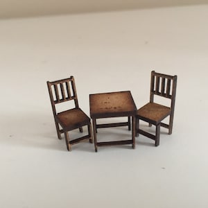 May include: A miniature wooden table set with two chairs. The table and chairs are brown and have a simple design.