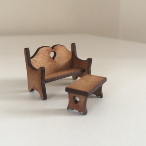 May include: A miniature wooden bench and table set. The bench has a heart-shaped cutout in the back and the table has a simple design with four legs.