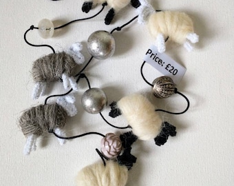 Sheep string hand made from British fleece. A long vertically hanging string of sheep in natural colours or multi colours as home decoration