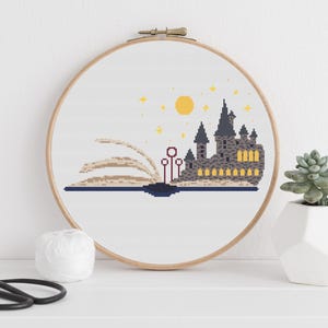 May include: A cross-stitch pattern of Hogwarts castle, a book, and the Deathly Hallows symbol on a white background.