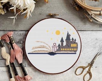 Puede incluir: Un patrón de punto de cruz de Hogwarts Castle que emerge de un libro con una luna amarilla y estrellas en el cielo.