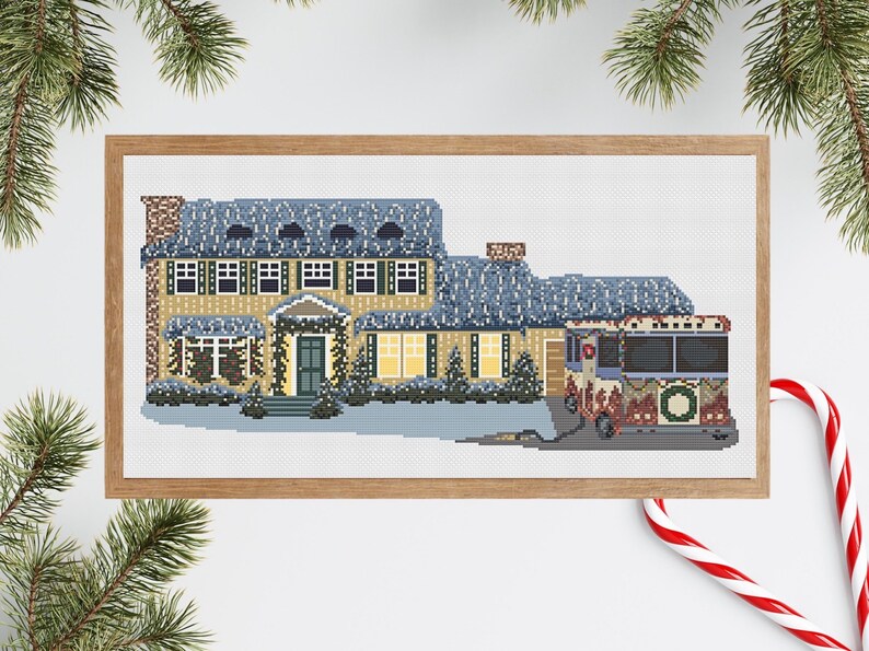 May include: A cross-stitch pattern of a yellow house with blue roof and snow on the roof, decorated with Christmas lights and a wreath on the front door. A red and white Christmas bus is parked in front of the house.