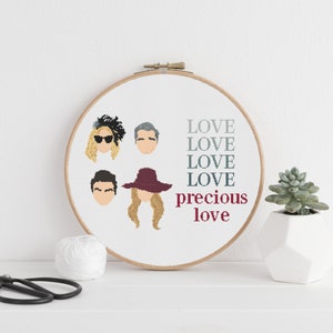 Peut inclure: Art de broderie en forme de cercle avec quatre portraits de dessins animés et le texte "LOVE LOVE LOVE LOVE precious love".