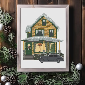 May include: A cross-stitch pattern of a yellow house with a green door and porch, covered in snow, with a black car parked in front. The house has a lit lamp in the window and a Christmas tree inside.