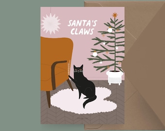 May include: A pink and white Christmas card with a black cat scratching a brown armchair. The card reads "Santa's Claws" and features a small Christmas tree with white ornaments.