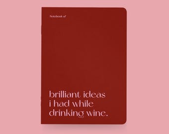 May include: A rectangular, red notebook with rounded corners. The text "Notebook of" is at the top, and below it, the words "brilliant ideas I had while drinking wine" are printed in white. The background is a light pink.