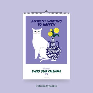 Könnte beinhalten: Wandkalender mit einer Illustration einer weißen Katze, einer blau-weißen Vase mit gelben Blumen und dem Text "ACCIDENT WAITING TO HAPPEN". Der Kalender trägt auch die Aufschrift "EVERY YEAR CALENDAR No 2" und hat eine Spiralbindung.