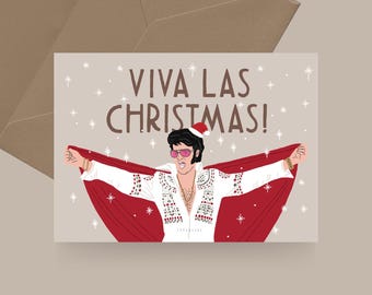 Op de afbeelding: Een kerstkaart met een cartoonillustratie van Elvis Presley die een kerstmanmuts en een wit jumpsuit met rode bies draagt. De tekst "Viva Las Christmas!" staat in witte letters op een beige achtergrond.