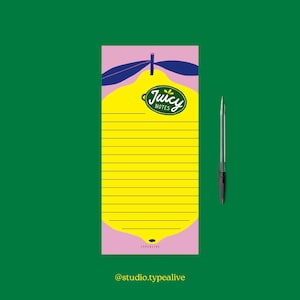 Può includere: Blocco note con un design a limone giallo e la scritta "Juicy Notes" su sfondo rosa. Il blocco note ha righe orizzontali e una penna. Lo sfondo è verde.