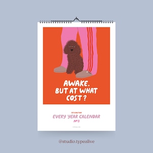 Può includere: Un calendario da parete con uno sfondo arancione vibrante presenta un barboncino marrone vicino a pantaloni della tuta rosa con strisce rosse. Il testo "AWAKE. BUT AT WHAT COST?" è visualizzato. Il calendario è intitolato "EVERY YEAR CALENDAR N°3".
