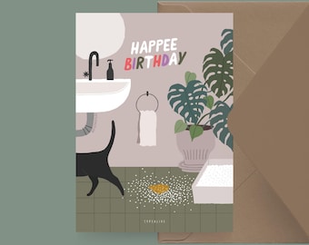 May include: A humorous birthday card featuring a black cat in a bathroom with a plant, a sink, and a litter box. The text on the card reads "Happee Birthday".