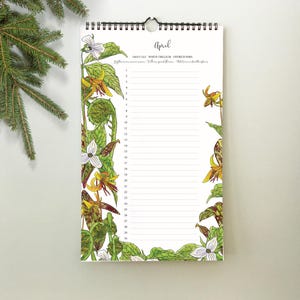 May include: A spiral-bound calendar for April, featuring botanical illustrations of wildflowers in shades of yellow, white, and green. The word "April" is written in cursive at the top. The calendar has lined spaces for daily entries.