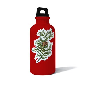 May include: Red water bottle with a white sticker of a green cedar branch with brown berries.