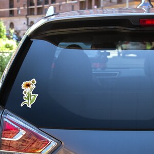 Puede incluir: Una pegatina para la ventana de un coche con una ilustraci&oacute;n de acuarela de una flor amarilla con hojas verdes.