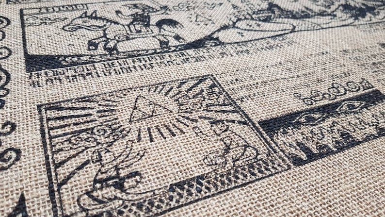 May include: A close-up of a brown burlap fabric with black ink drawings of various symbols and figures. The drawings include a triangle with rays of light, a figure riding a horse, and a group of figures standing in a line.