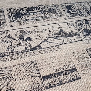 May include: A burlap fabric tapestry with black ink illustrations of a knight riding a horse, a castle, and other fantasy scenes. The tapestry has a border of decorative swirls.