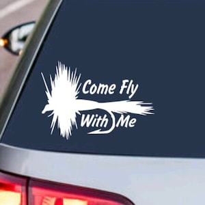Puede incluir: Calcomanía de vinilo blanco con un señuelo de pesca con mosca y el texto "Come Fly With Me" en un coche azul oscuro.